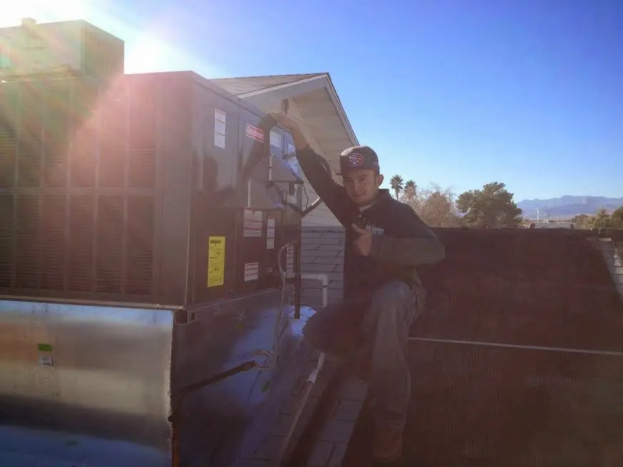 HVAC technician performing HVAC Inspection on a rooftop unit in Alafaya